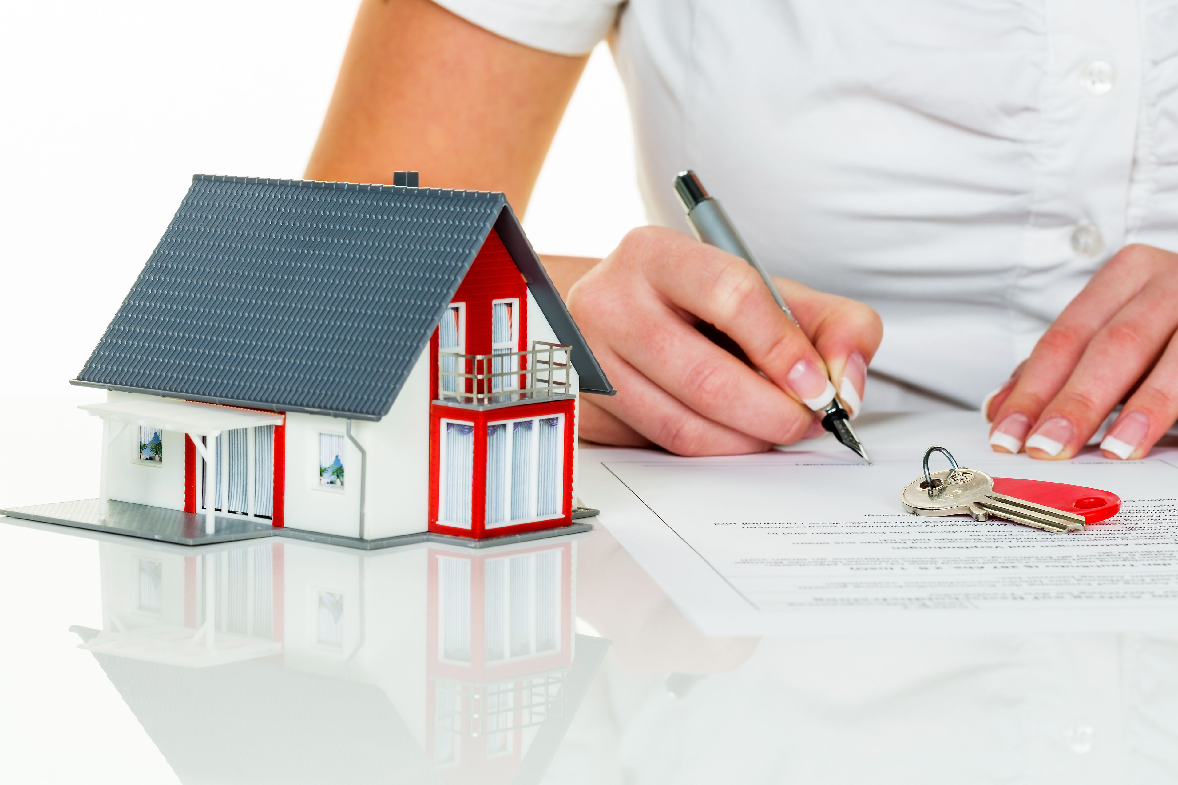 a woman signs a purchase agreement for a house in a real estate agent.