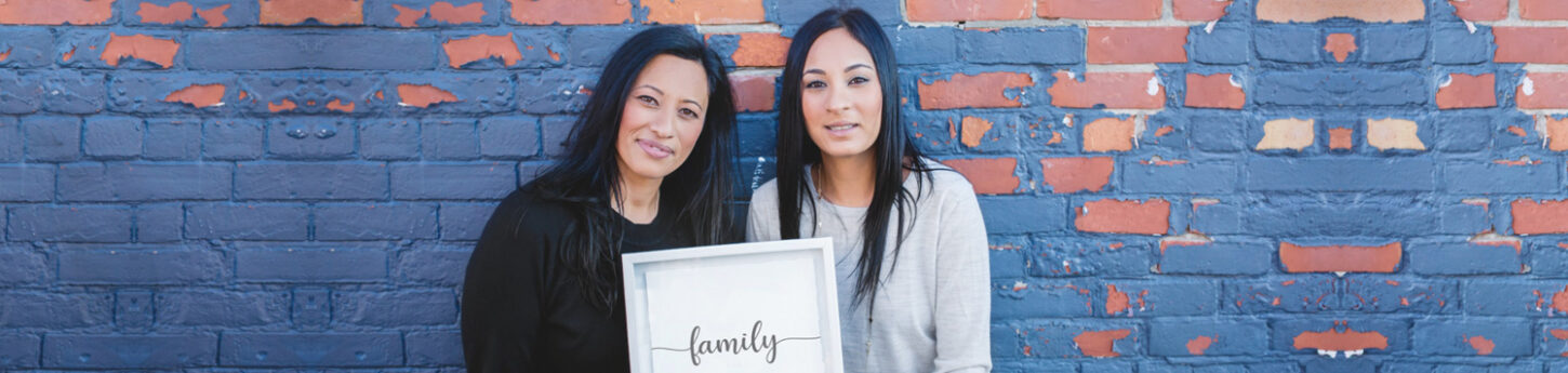 Reena and Ritu holding up a family sign in Toronto Ontario